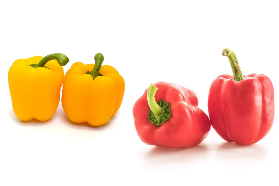 Fresh yellow and red bell peppers on a wooden surface, rich in vitamin C and antioxidants, nutritious foods for glowing skin.