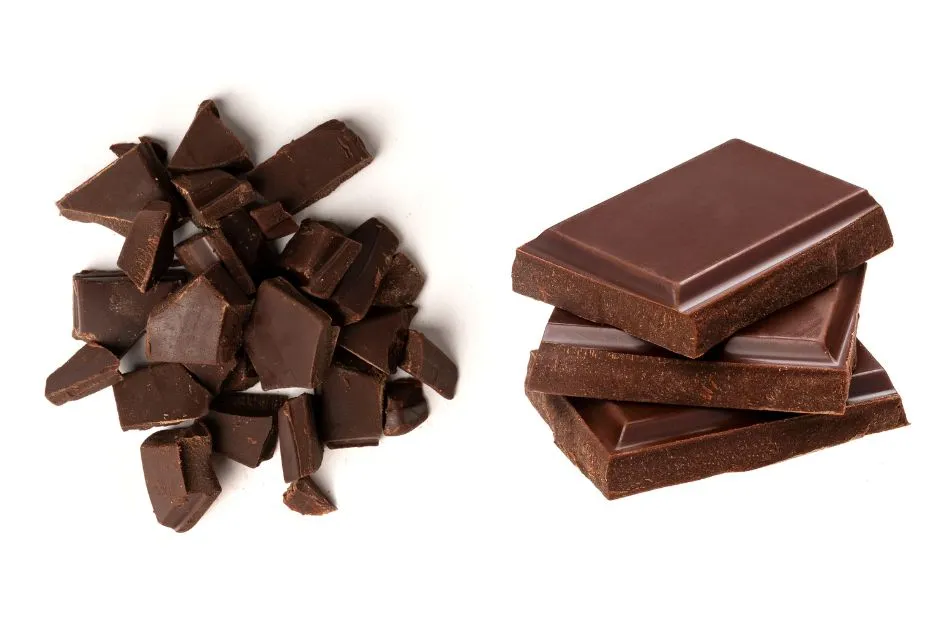 Chunks and bars of rich dark chocolate, high in antioxidants and flavonoids, known to support skin hydration and improve complexion as part of a diet for glowing skin.